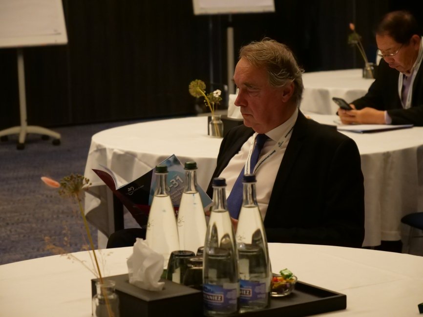Conference delegate reading the program guide at a roundtable during the Women's Health & Nursing World Summit