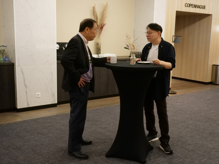 Two conference attendees networking and chatting over coffee between sessions
