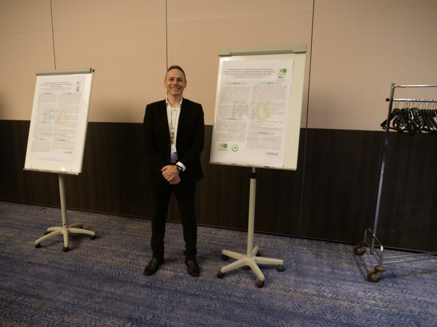Researcher standing beside his poster presentation at the Women's Health & Nursing World Summit